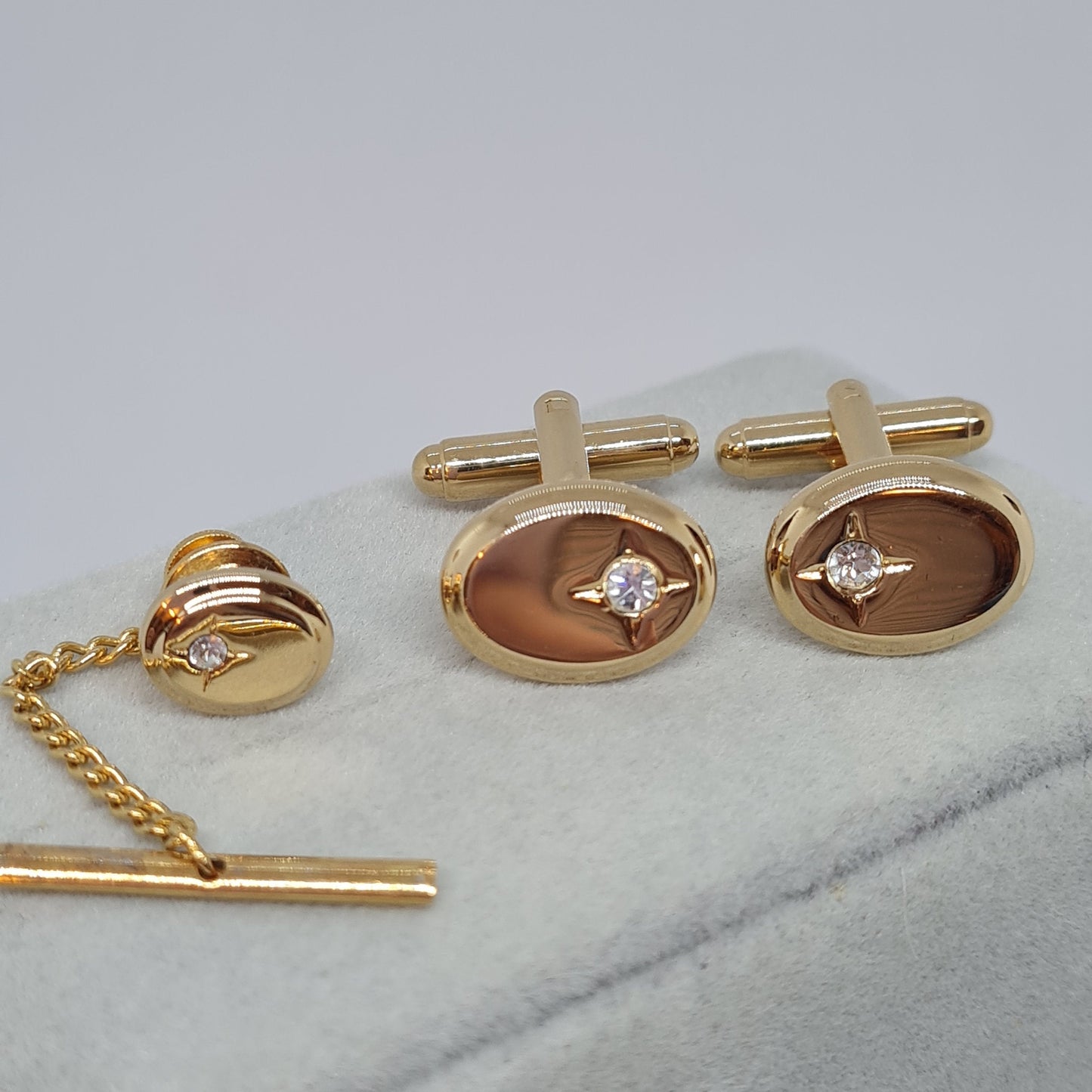 Vintage tiny cufflinks & tie tack set. Gloss gold tone oval cuff links with clear rhinestones.