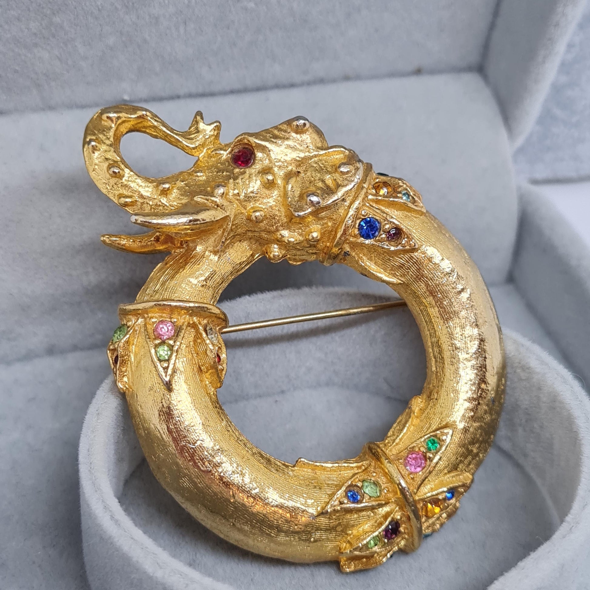 Vintage circus elephant brooch. Circle gold-tone metal with rainbow glass rhinestones brooch pin.