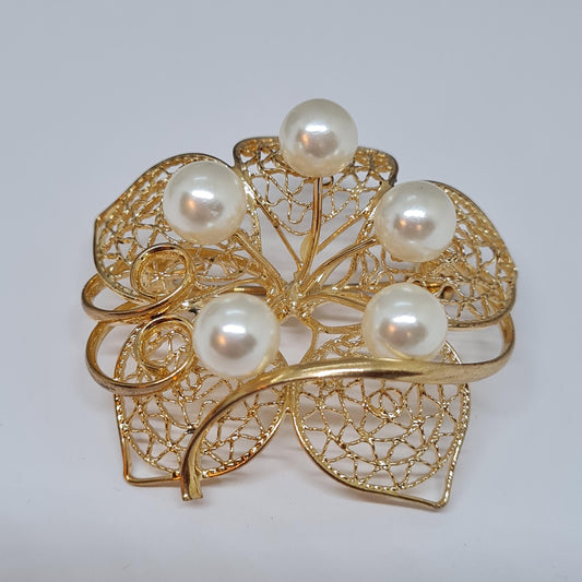 Vintage filigree flower brooch. Gold-tone metal with faux pearl brooch pin.