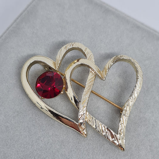 Vintage two-heart brooch. Gloss and textured gold-tone metal brooch pin with red rhinestone. Valentine's Day gift.