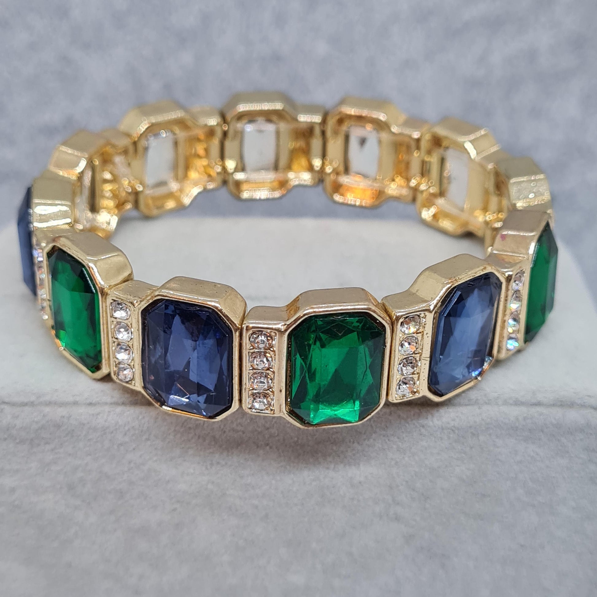 Vintage stretchy bracelet. Gold-tone metal with blue and green plastic cabochon and clear rhinestone. Gift idea for Christmas.