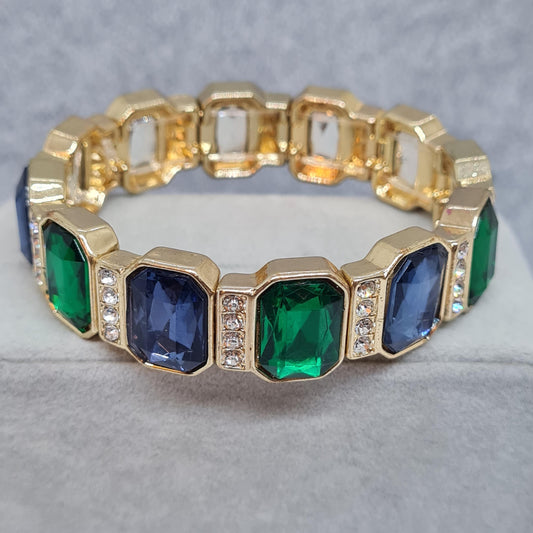 Vintage stretchy bracelet. Gold-tone metal with blue and green plastic cabochon and clear rhinestone. Gift idea for Christmas.