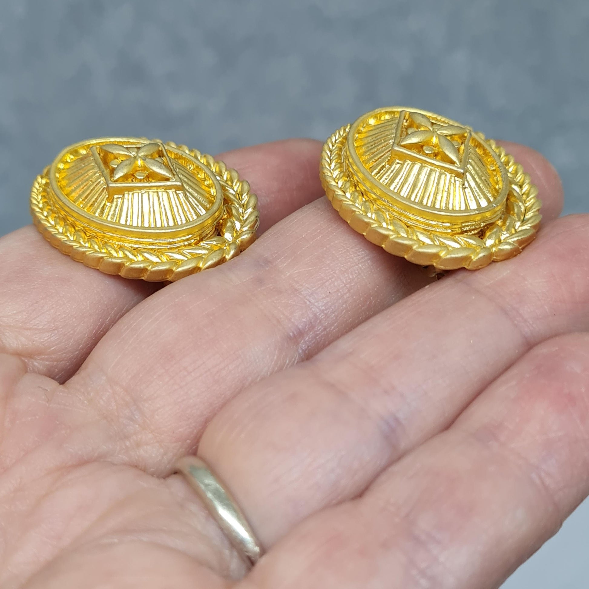 Vintage heraldic style clip-on earrings Matte gold tone textured metal oval clip earrings