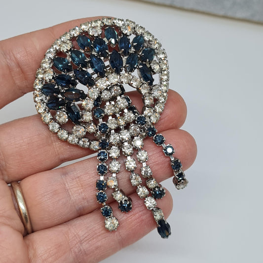 It's an awesome vintage waterfall brooch. Silver-tone metal with blue and clear glass rhinestone brooch pin.