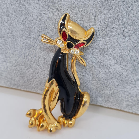 Vintage enamel cat brooch. Gold-tone metal with black and red enamel and clear rhinestone brooch pin.