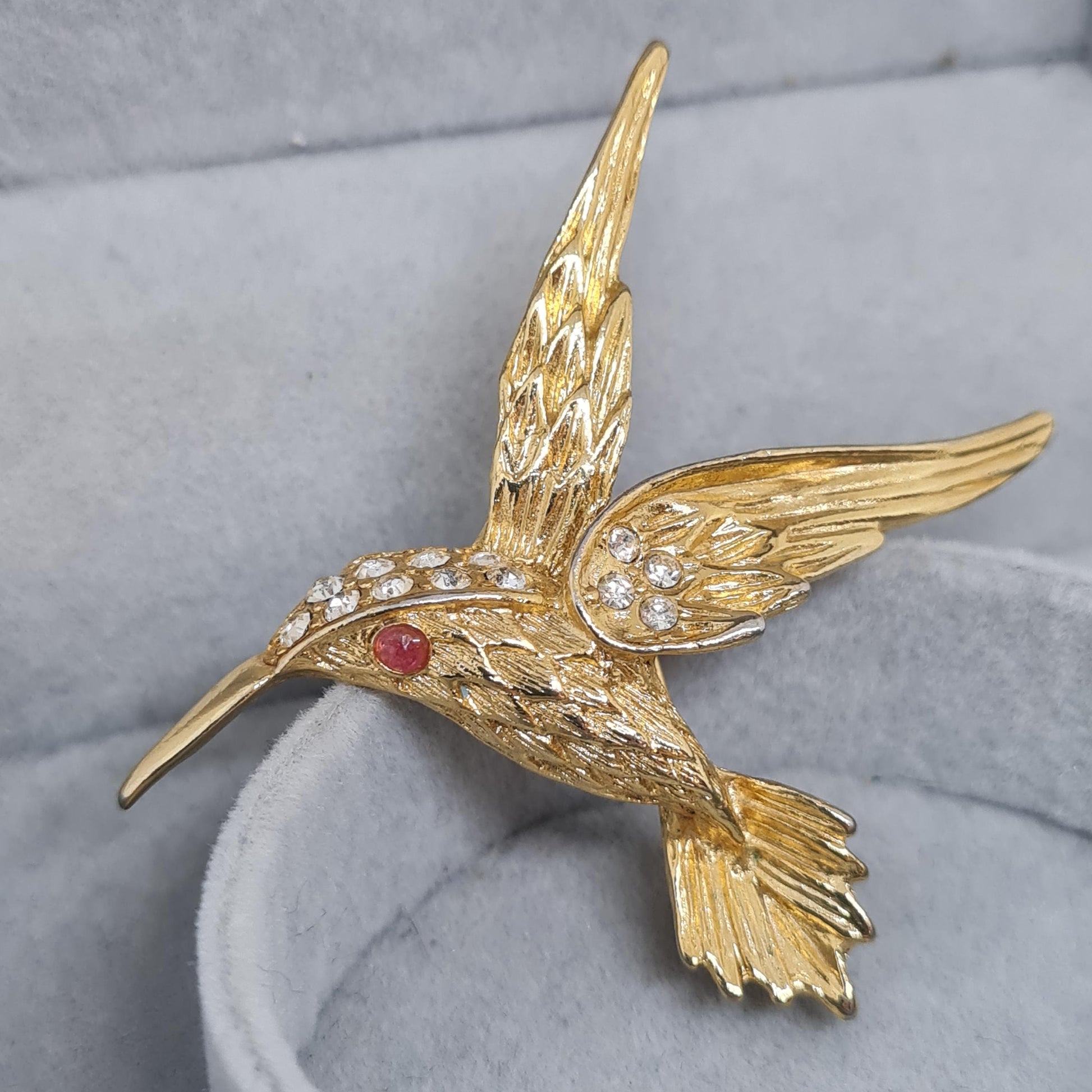 Vintage hummingbird brooch. Gold-tone textured metal with clear rhinestone. Awesome bird brooch pin.
