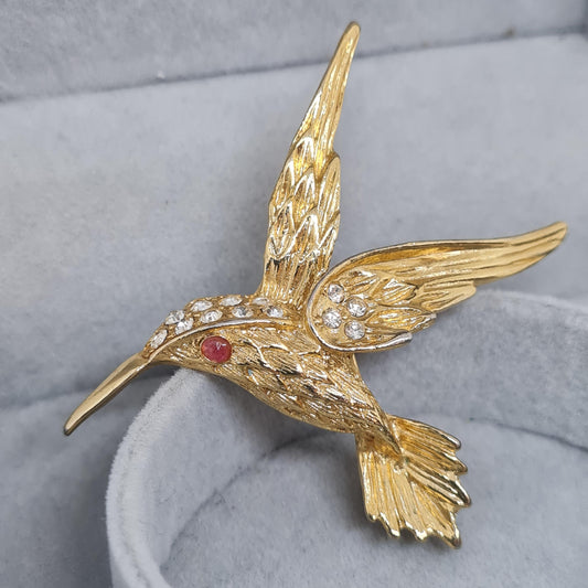 Vintage hummingbird brooch. Gold-tone textured metal with clear rhinestone. Awesome bird brooch pin.