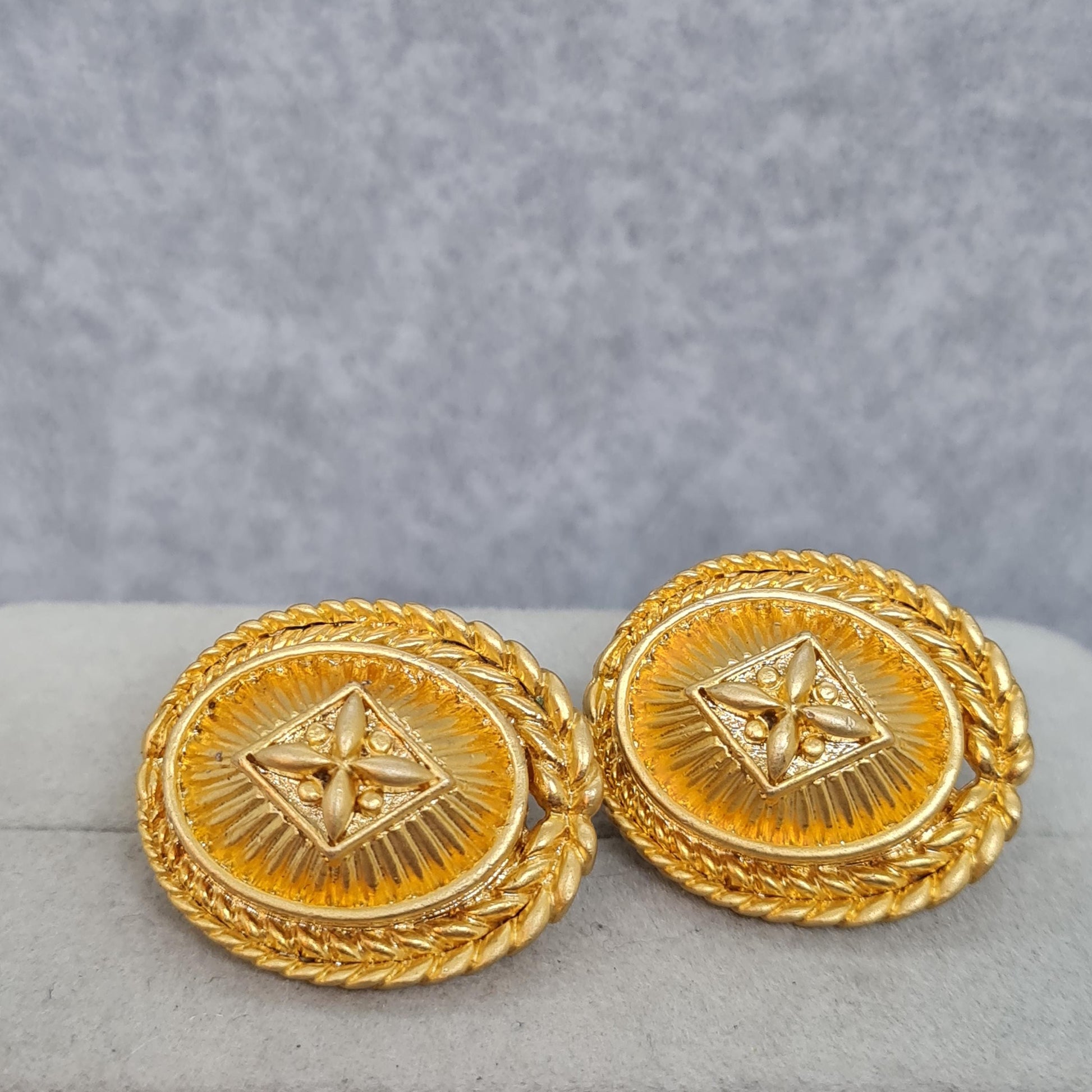 Vintage heraldic style clip-on earrings Matte gold tone textured metal oval clip earrings