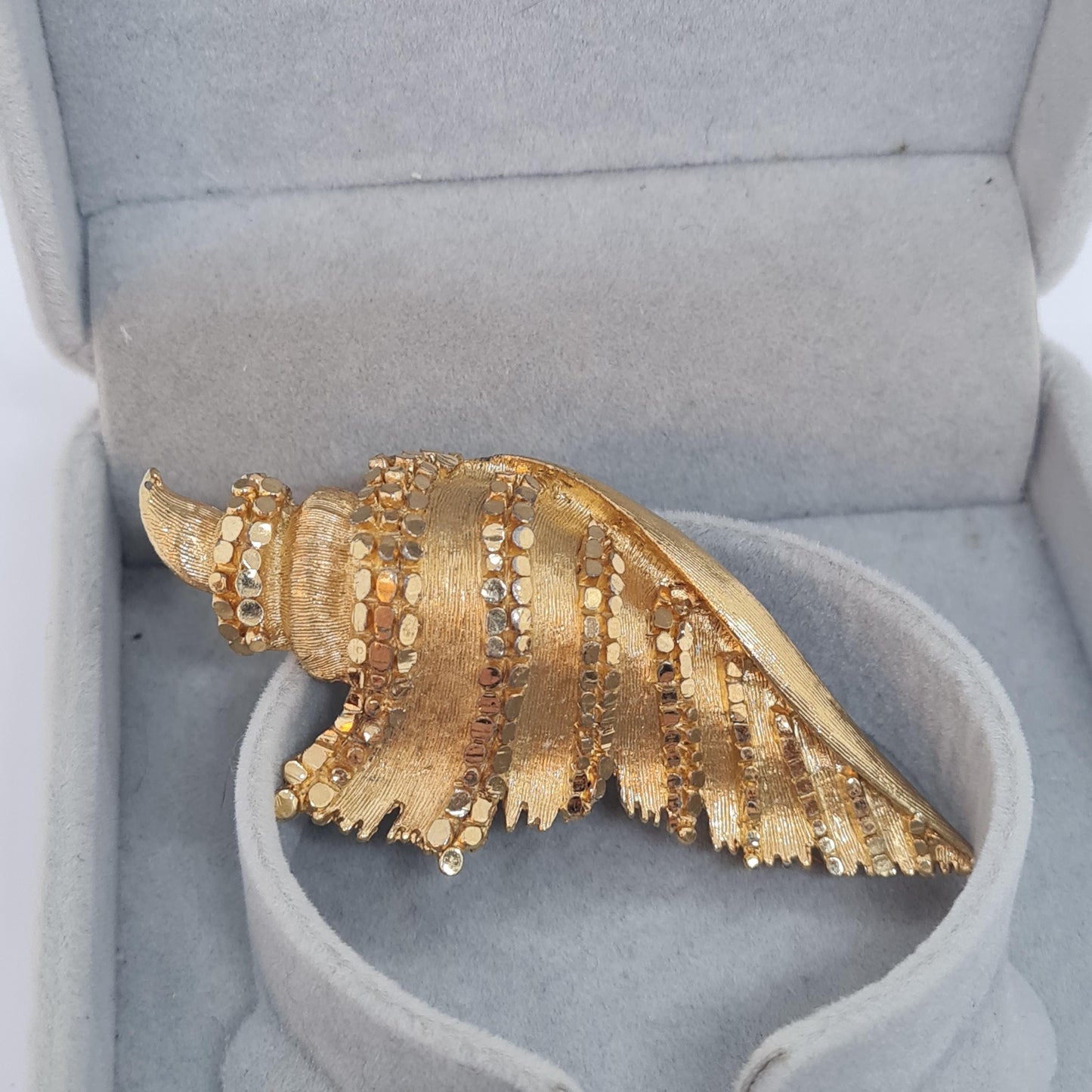 Vintage BSK seashell brooch with textured gold-tone metal pin.