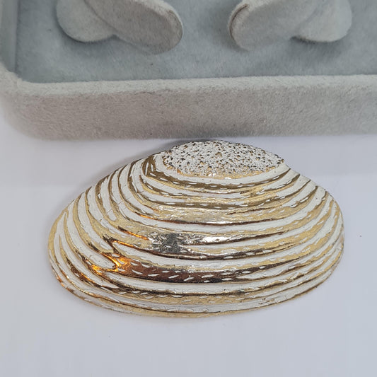 Vintage seashell brooch with textured gold-tone metal pin.